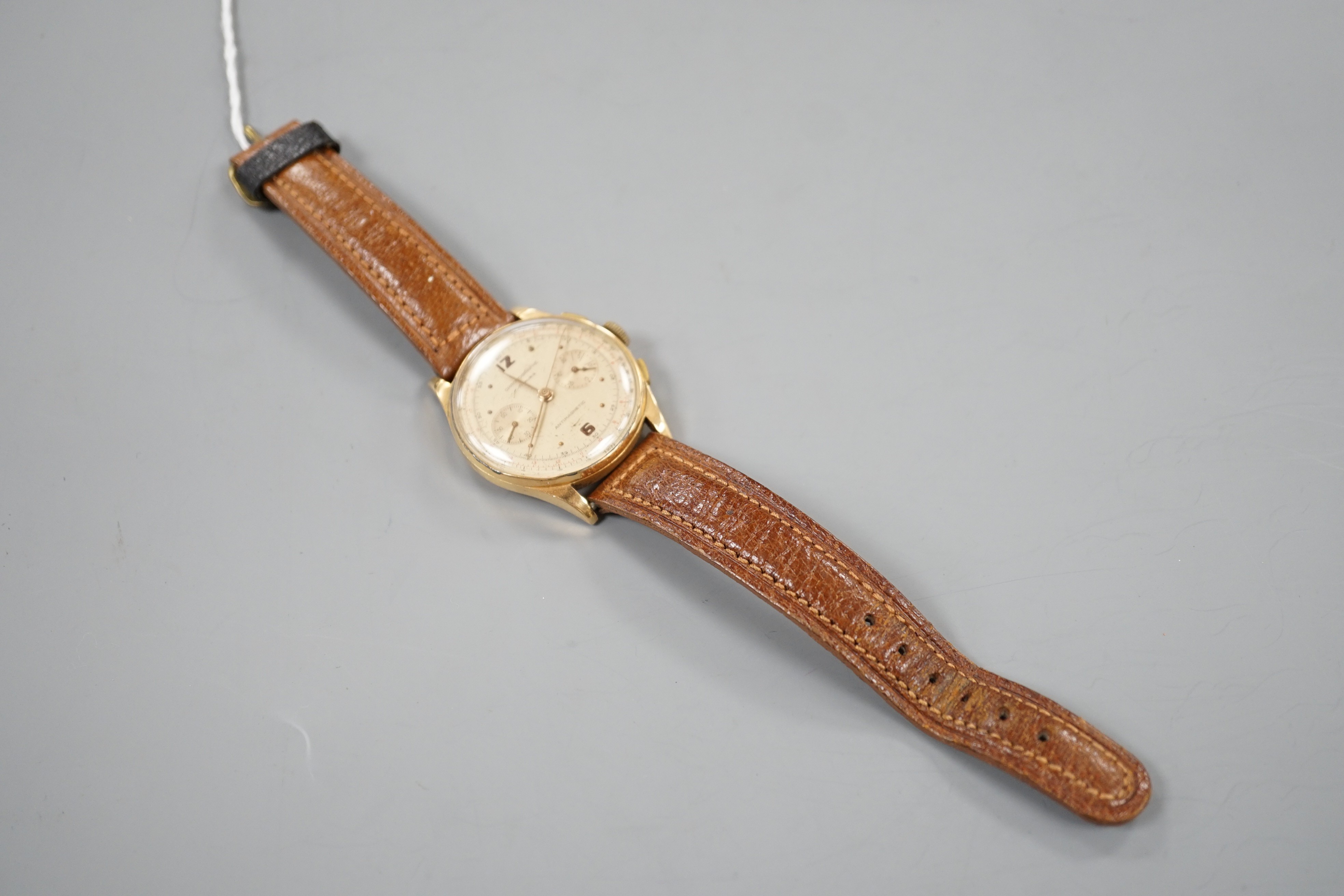 A 1940/1950's? Swiss 18k chronograph wrist watch, with two subsidiary dials, on a brown leather strap, case diameter 37mm, gross weight 45.5 grams.